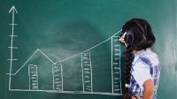 Photo of elementary student drawing graph on chalk board