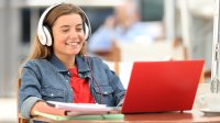 Student using a laptop while wearing headphones