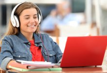 Student using a laptop while wearing headphones