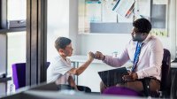 Teacher and student bumping their fists together