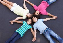 Photo of elementary students lying on ground in a pattern