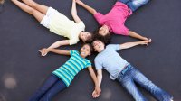 Photo of elementary students lying on ground in a pattern