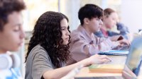 Photo of high school students working on computer in classroom