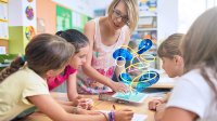 teacher shows iPad to group of elementary students