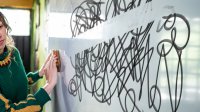 teacher erasing overwhelming scribble on whiteboard