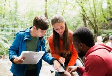 Photo of students with teacher outside working on project