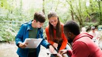 Photo of students with teacher outside working on project