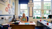 Photo of teacher sitting at her desk in classroom