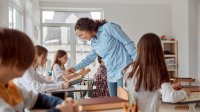 Photo of middle school teacher talking to student in classroom