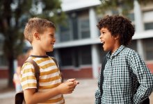 Two elementary students talking outside of school