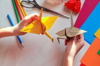 children holding two paper cranes