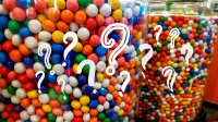 Containers of gumballs covered in question marks
