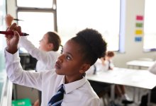 Photo of middle school students writing on white board in classroom