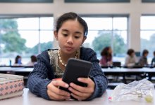 Photo of middle school student using cellphone at lunch