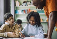 Photo of teacher conveying classroom expectations by circulating to student pairs