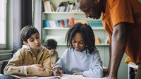 Photo of teacher conveying classroom expectations by circulating to student pairs