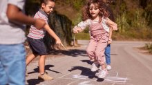 Photo of elementary school children playing hopscotch