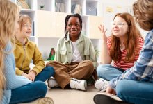 Elementary students playing an ELA game together while sitting on the floor in a circle