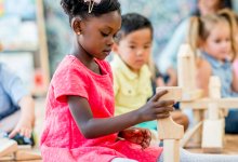 Preschool student building with wooden blocks