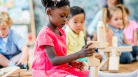 Preschool student building with wooden blocks