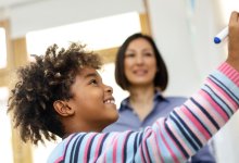 Photo of elementary student writing on board