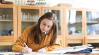 Photo of high school student writing in classroom