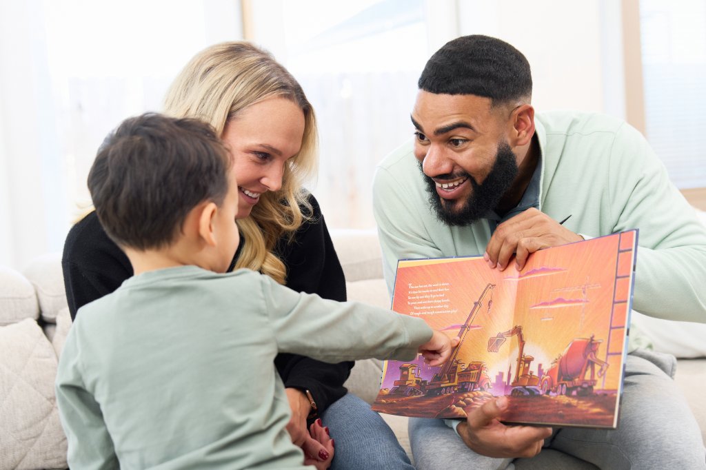 Spencer Russell reading a book with a young child