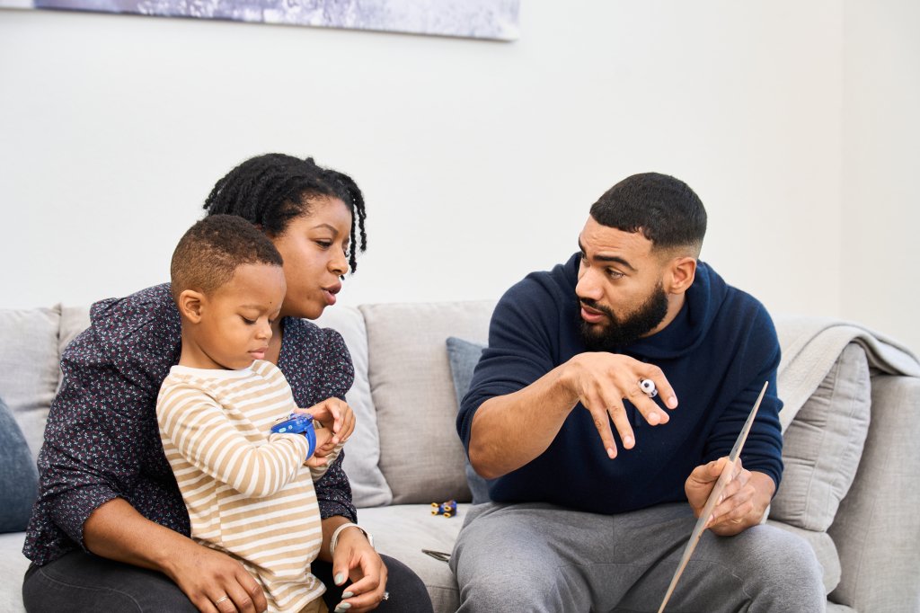 Spencer Russell explaining a concept to a young student and parent