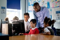 Teacher looking over student group working on a STEM activity