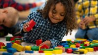 Preschooler building using wooden blocks