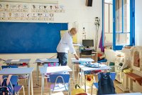 Teacher laying worksheets on students' desks