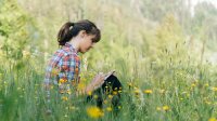 Photo of high school student writing in field