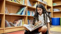 Photo of middle school student reading graphic novel at school