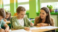 A teacher affirming and engaging with a student as they work