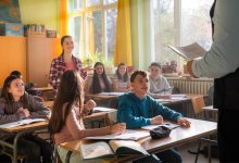 Middle school student standing and talking to teacher