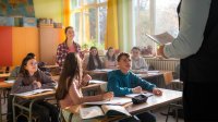 Middle school student standing and talking to teacher