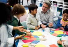 A small group of elementary students working with blocks as a teacher guides them