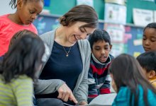 Students in english language arts class surrounding a teacher reading a picture book