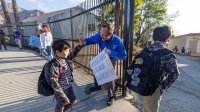 Principal John Maynard greets students as they return to Don Benito Fundamental School in Pasadena, CA on Wednesday, Jan. 29, 2025 after being closed for three weeks because of the Eaton fire.