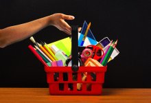 hand lifting a basket of school supplies