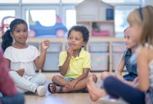 Preschool students sitting in a circle playing a game, representing the idea of brain breaks for students