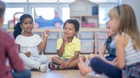 Preschool students sitting in a circle playing a game, representing the idea of brain breaks for students