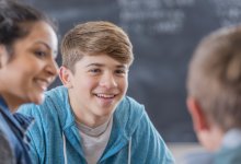 Students talking in class as part of weekly community building activities.