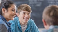 Students talking in class as part of weekly community building activities.