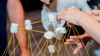 Elementary students using creativity, marshmallows, and spaghetti sticks to build structures