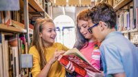 Elementary students in a library excitedly talking about a book