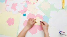 Child's hands making a paper flower creative project, representing the idea of showcasing student growth