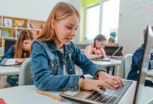 Students completing a test on computers while taking notes to ensure they don't miss questions they know the answer to