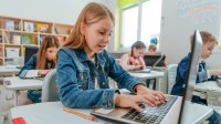 Students completing a test on computers while taking notes to ensure they don't miss questions they know the answer to