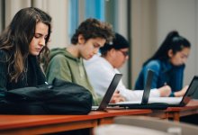 High school students using laptops as they use AI to support PBL
